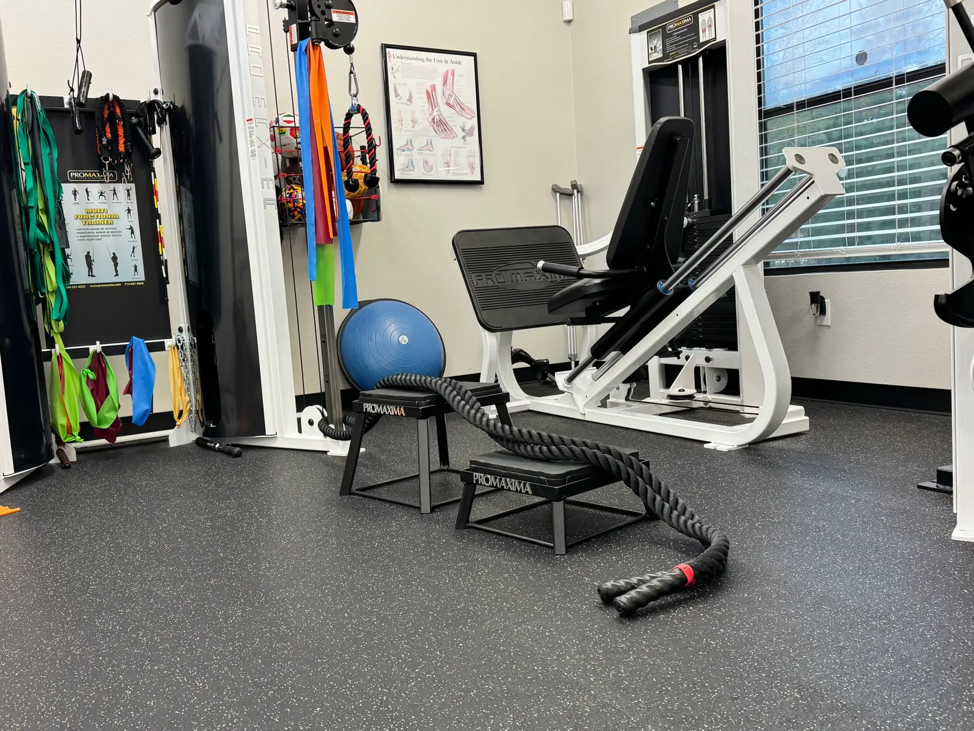 Leg press machine, medicine ball and battle rope in the strength corner of the clinic.
